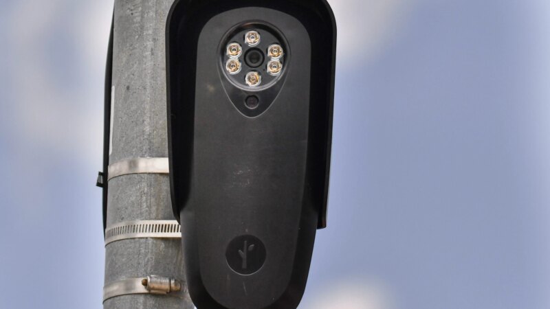 A Flock Safety license-plate-reader camera mounted on a pole against the sky (Photo: ThoughtCatalog)