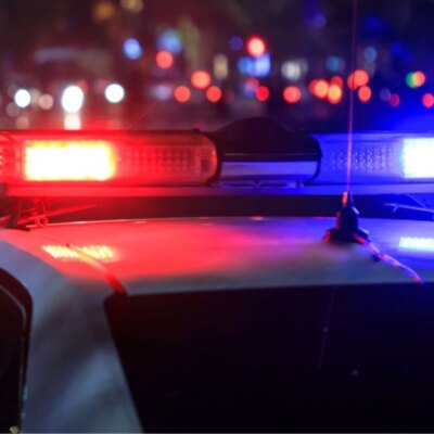 Police car with flashing lights at a crime scene at night