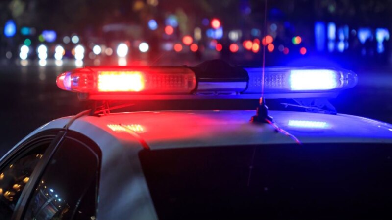 Police car with flashing lights at a crime scene at night