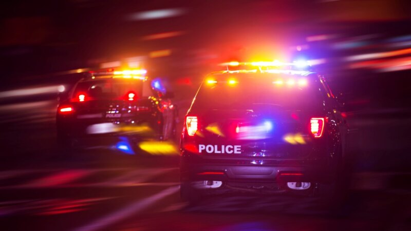 Police vehicle with flashing lights on a road at night