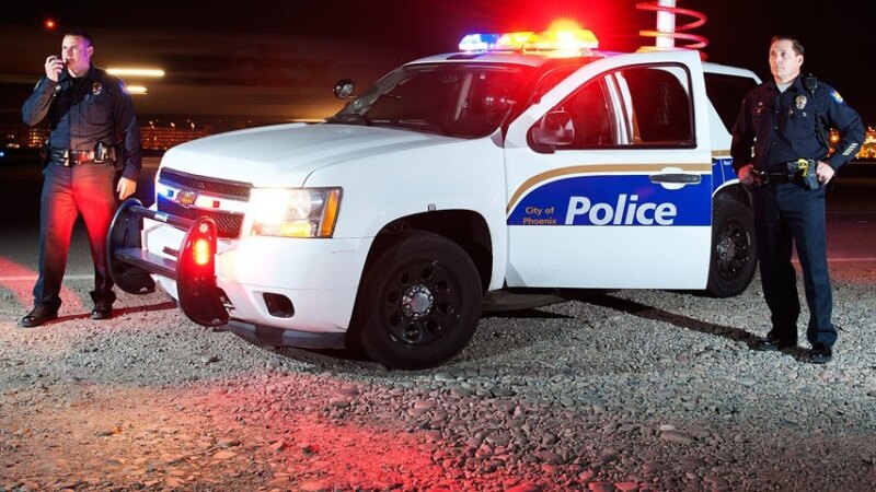 City of Phoenix police patrol car at night with officers on scene